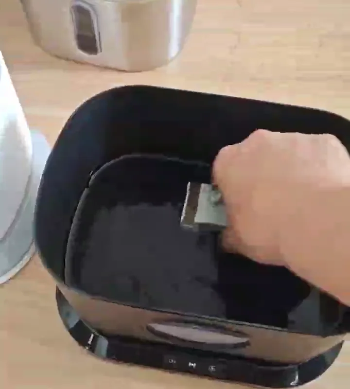 Hand reaching the wireless pump module in an open black CWF-W1 reservoir during assembly