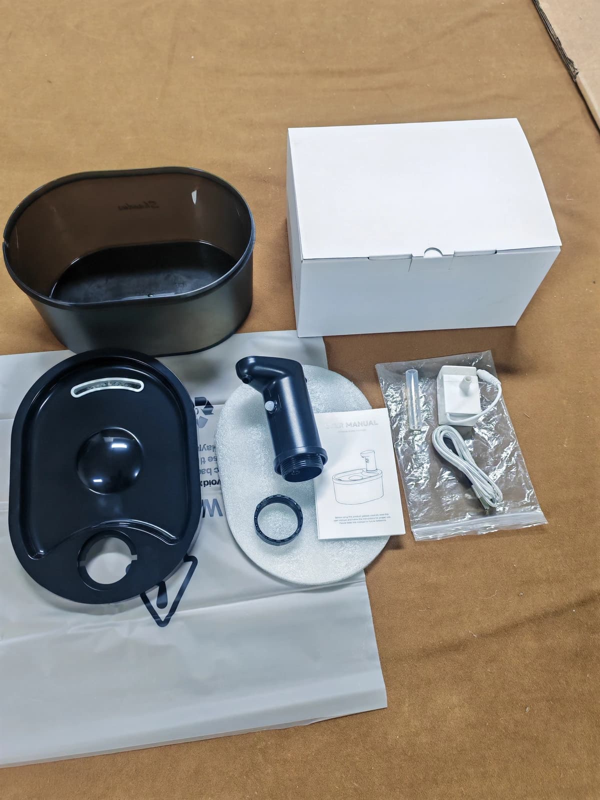 Disassembled oval fountain kit with tray, outlet module, reservoir and conventional wired pump