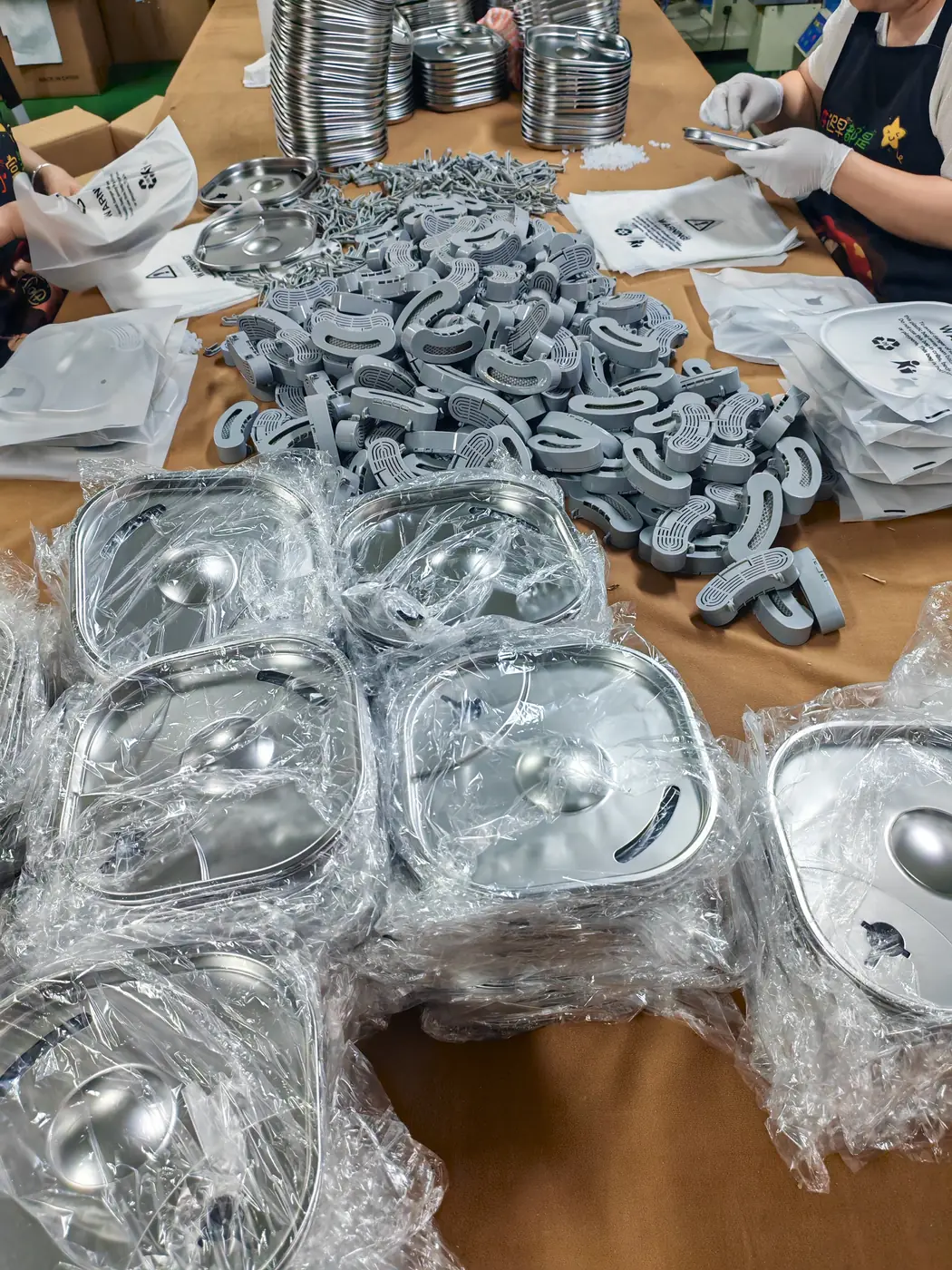 Workers preparing fountain trays, outlets and accessory components at a worktable
