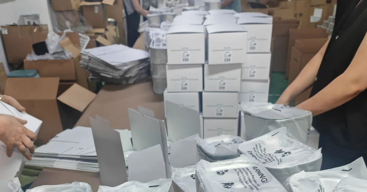 Protected stainless steel cat fountain units and retail boxes arranged at a packing station before master-carton packing