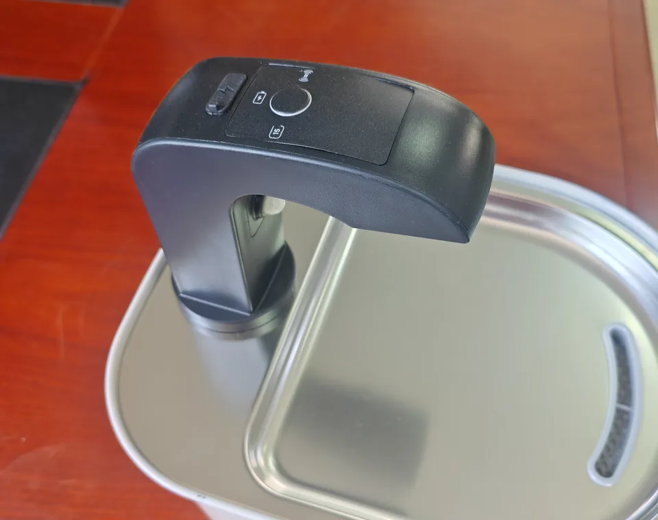 Close view of a rechargeable cat water fountain control module and stainless steel drinking tray during sample review