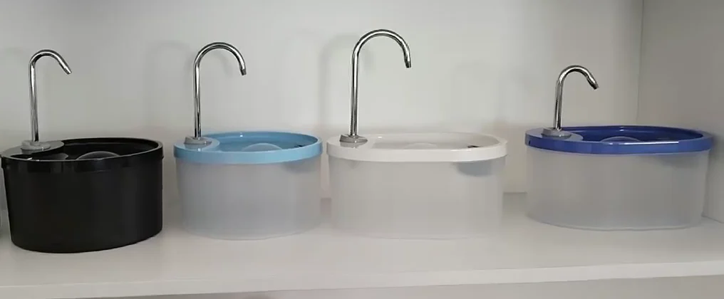 Round plastic fountain samples with black, light blue, white and blue tops and different curved metal spouts