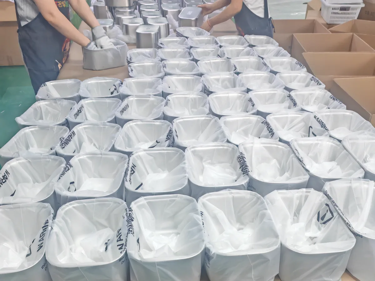 Fountelio workers arranging protected stainless steel fountain bodies and components for packing